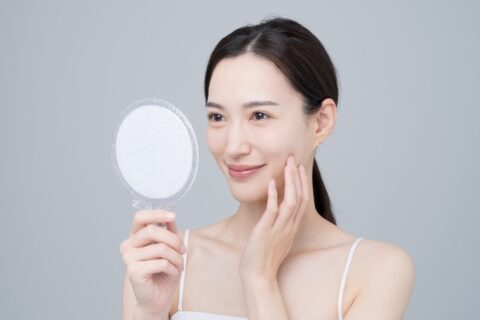 間の下の脂肪を鏡で見る女性