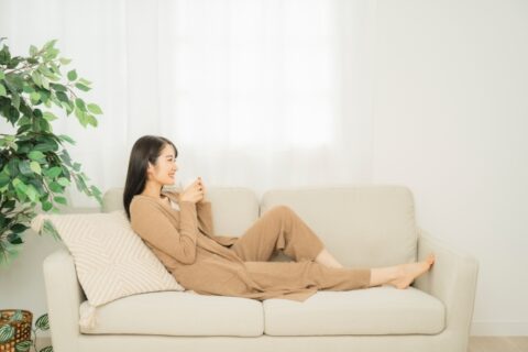 クマ取り整形後ソファで安静に過ごす女性