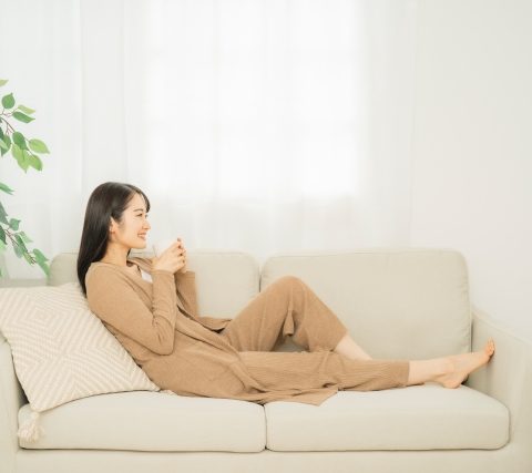 クマ取り整形後ソファで安静に過ごす女性