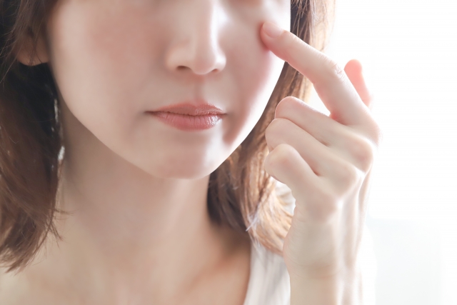 目元に指をあててたるみを気にする女性