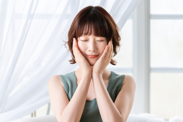 顔に手を当てる女性