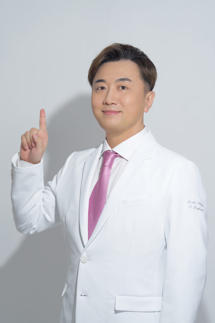 人差し指を立ててほほ笑む和倉院長