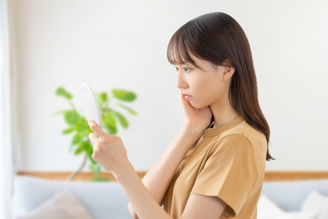 鏡を見て悩む女性
