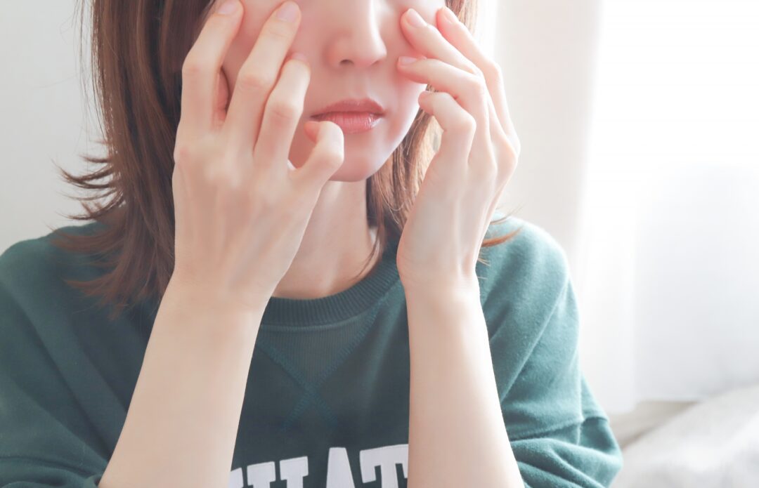 目元のクマを気にする女性の写真